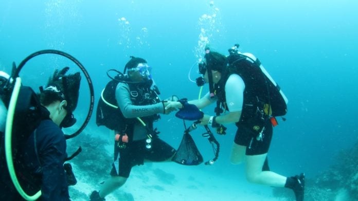 PADI Dive Instructor Bethy Driscoll congratulates T Cumming on completing his Deep Adventure Dive, Fiji 2016