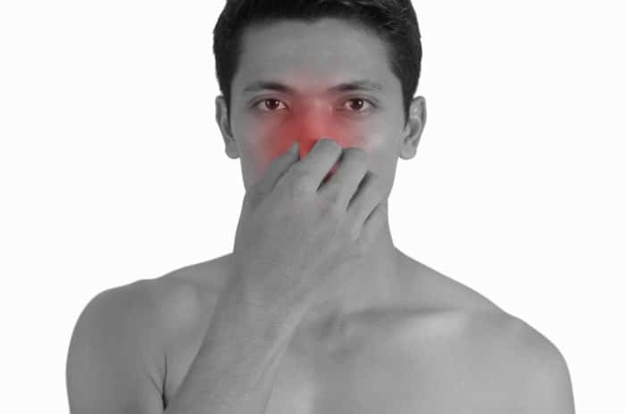 Man holding his nose because of sinus pain.