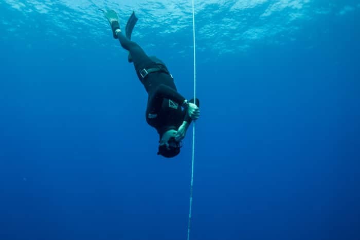 Freediver descending down a line and equalizing (Photo: Immersion Freediving)