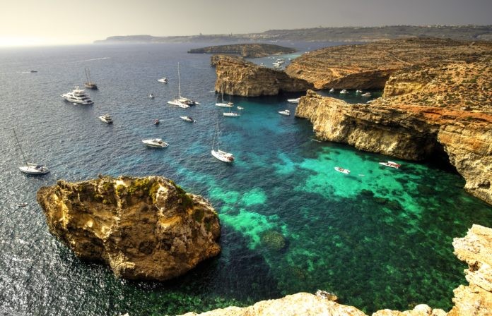 Yachts and leisure boats moored on the blue lagoon of Comino Island, Malta.