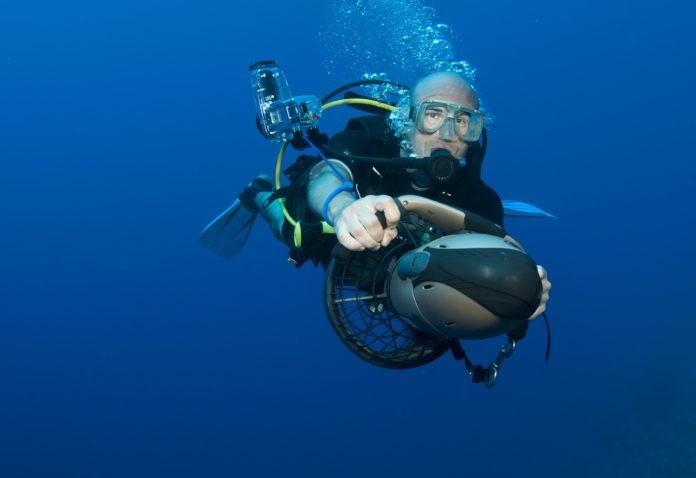 Scuba Diver plays on underwater scooter / diver propulsion vehicle