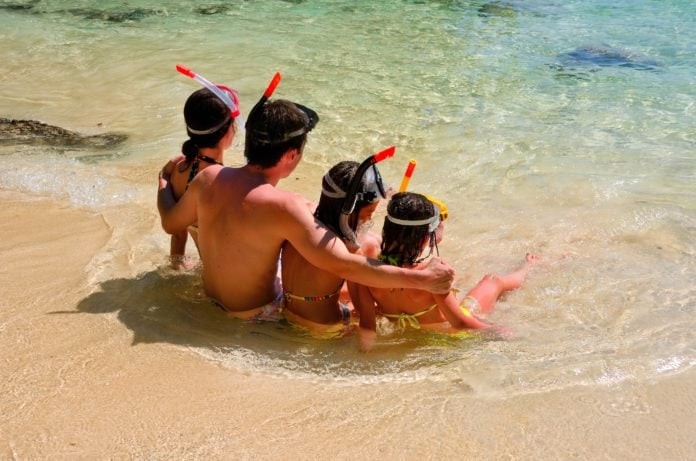 Happy family snorkeling and having fun on beach vacation