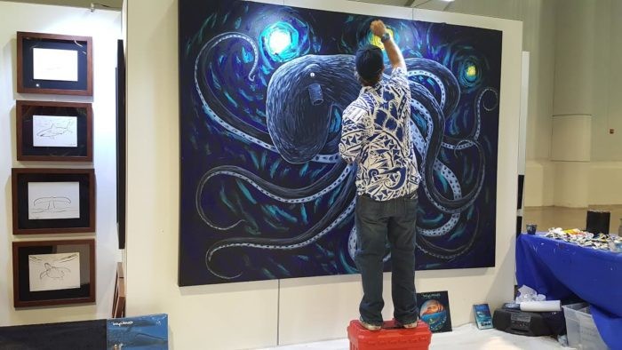 Wyland painting a canvas at DEMA Show 2016