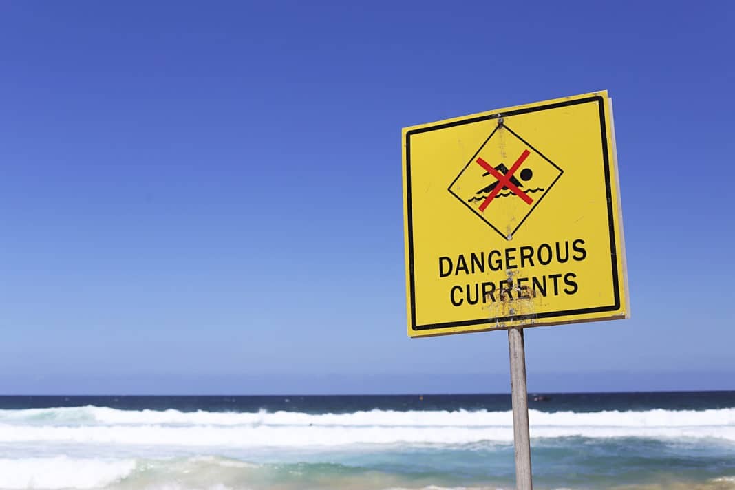 Dangerous currents sign on the beach at sunny day