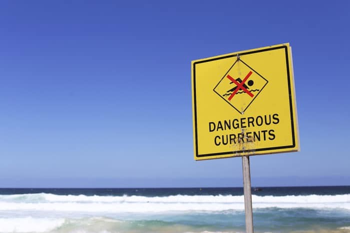 Dangerous currents sign on the beach at sunny day