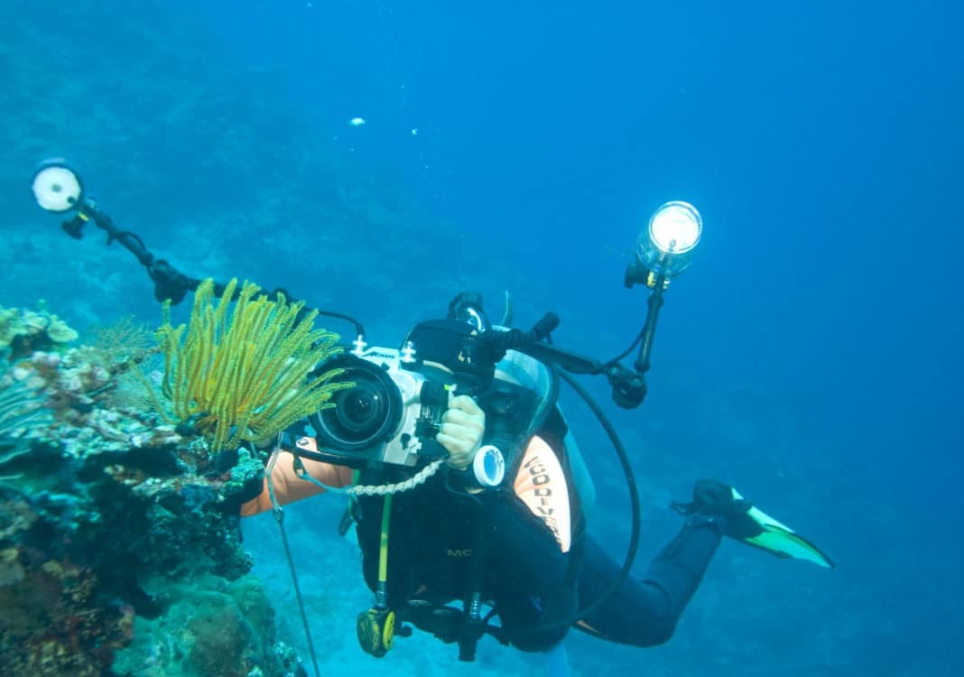 A diver with camera taking pictures of reef