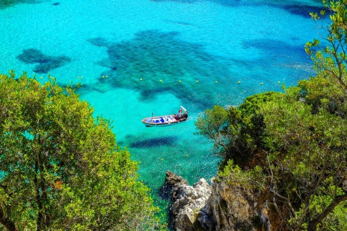 Aerial view on the boat on the crystal sea waer on the beach Paleokastritsa on the Island Corfu, Greece.