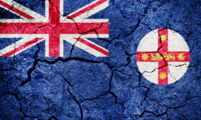 New South Wales flag on dry earth ground texture background