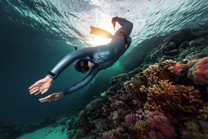 Freediver swimming underwater over vivid coral reef. Red Sea, Egypt