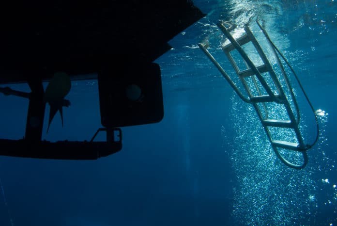 underneath the dive boat where scuba divers return. bubbles can often be seen cascading into the ladder rudder and propeller