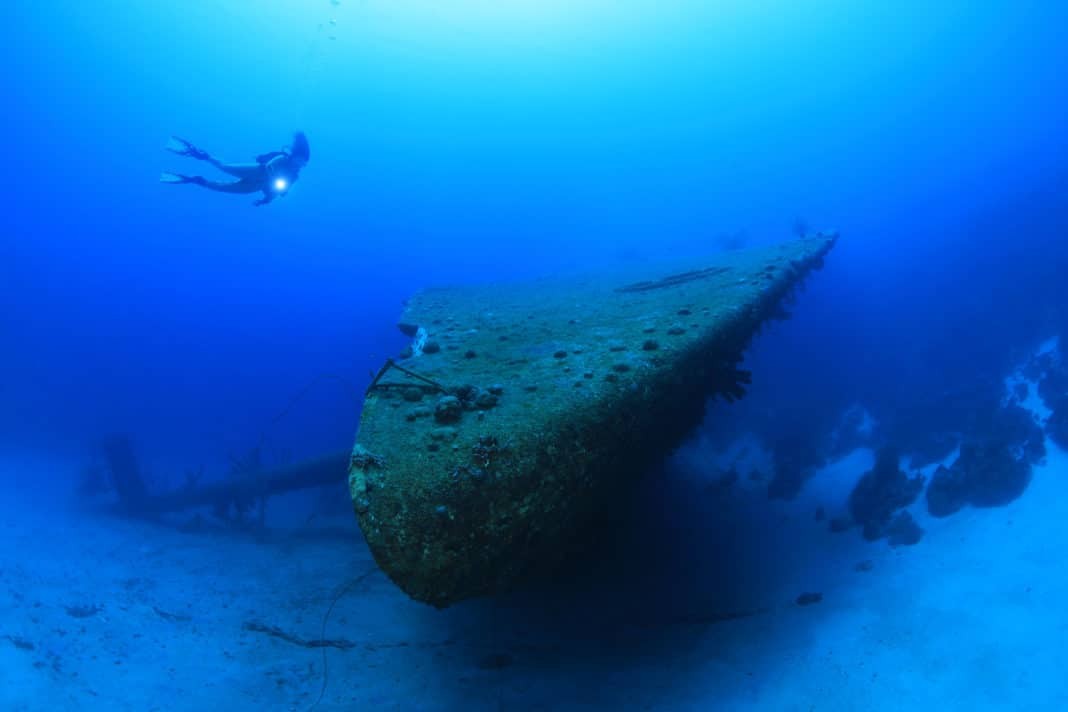 Shipwreck of the Hilma Hooker and scuba diver underwater in the caribbean sea of Bonaire