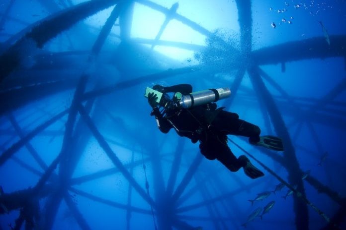 Scuba Diver under an oil rig
