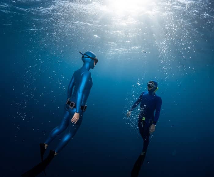Two freedivers ascending together.
