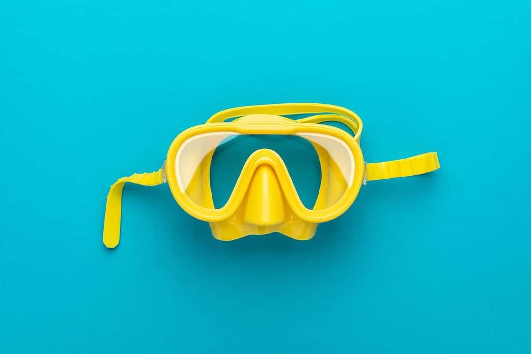 yellow diving mask over blue background