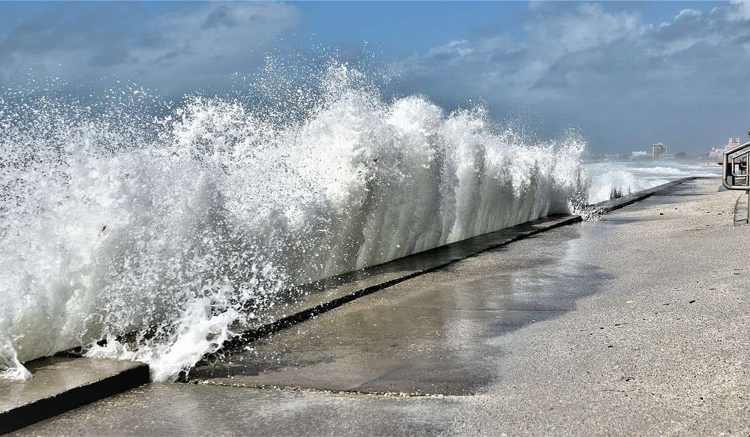Large wave crashing into a beach wall