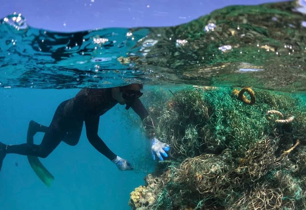 Diver Ryan Naluai works on removing a large derelict fishing net at Kamokuokamohoali?i / Maro Reef. (Image credit: James Morioka/PMDP)