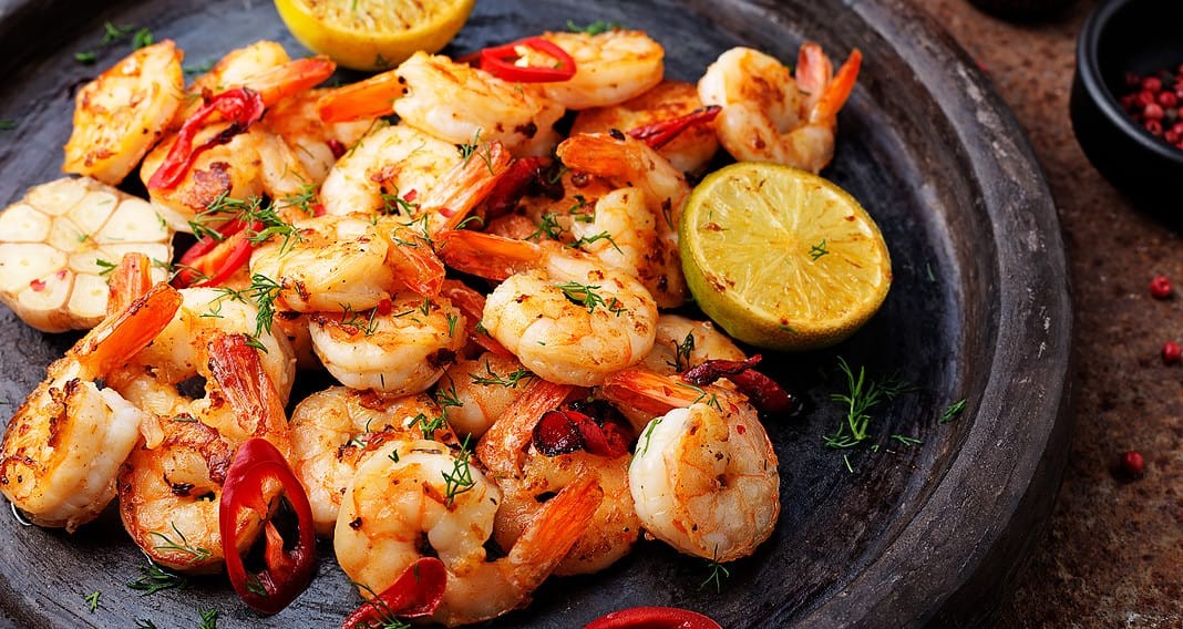 Prawns Shrimps roasted on pan with lemon and garlic (Adobe Stock)